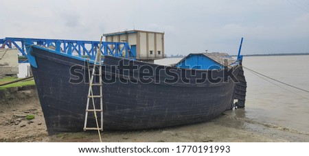 Vintage black wooden boat on river bank