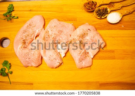 Meat steaks and various spices on a wooden Board. Close up.