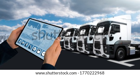 Manager with a digital tablet on the background of semi trucks. Fleet management Royalty-Free Stock Photo #1770222968