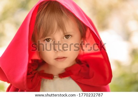 Close-up portrait of a girl in a fabulous costume of Little Red Riding Hood.