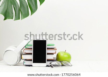 Office workplace desk table with smartphone, supplies and apple over white background. With space for your text or app