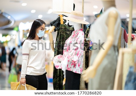 Shopping is a major pastime in Asian regions woman wearing face mask shopping in department store during corona virus.New normal live social relaxation period.