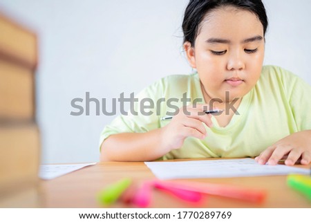Back to school concept. An Asian girl is doing her homework, practice doing skill-enhancing exercises.