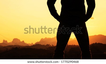 Black silhouette of man at sunset mountains.