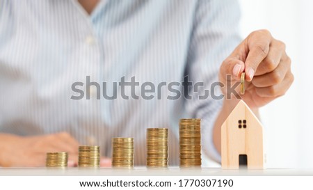 Property investment and house mortgage financial concept, hand of a businessman who is stacking coins for Real estate investment, saving for buying for housing or speculation Royalty-Free Stock Photo #1770307190