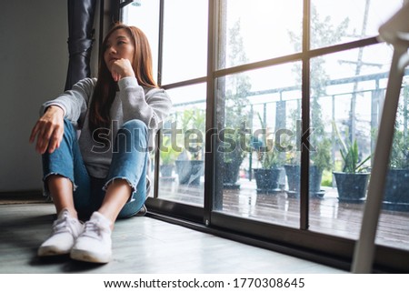 A sad and stressed young asian woman sitting alone in the room