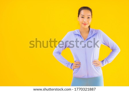 Portrait beautiful young asian sport woman with sportwear ready for exercise on yellow isolated background