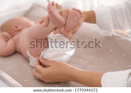 Mother changing her baby's diaper on table, closeup Royalty-Free Stock Photo #1770344372