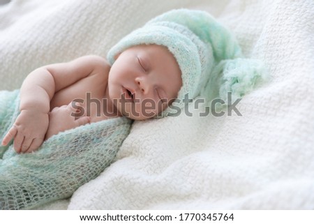 Cute newborn baby in warm hat sleeping on white plaid Royalty-Free Stock Photo #1770345764