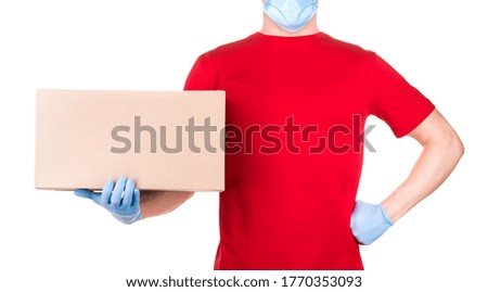 Man in red t-shirt and blue medical gloves holding cardboard box isolated white background with clipping path. Concept of safety delivery in virus or coronavirus quarantine