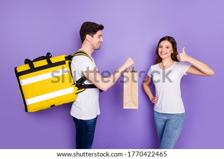 Profile photo overjoyed lady raise thumb finger up advising fast delivery courier guy hold present bag speed best service quarantine order wear t-shirt jeans isolated purple color background