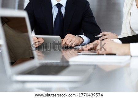 Business people working together at meeting in a modern office. Unknown businessman and woman with colleagues or lawyers at negotiation about contract