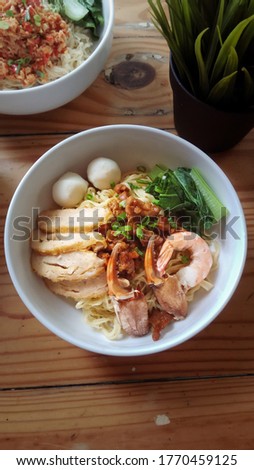 Bakmi Kepiting or Crab Noodles, Indonesian cuisine made of noodle topped with minced chicken, served with vegetables, fish balls, slice of minced chicken rolls, crab and shrimp. Selective focus Royalty-Free Stock Photo #1770459125