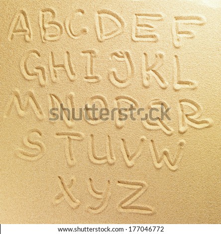 Alphabet letters handwritten in the sand on the beach Royalty-Free Stock Photo #177046772