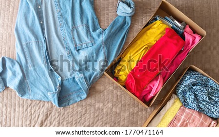 Colorful clothes in boxes. Clothing donation concept