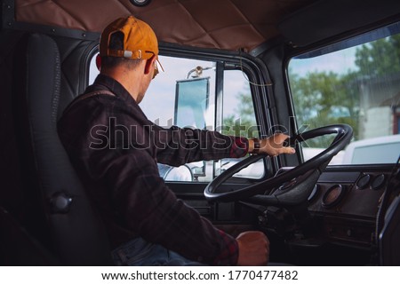 Caucasian Trucker in His 40s Inside Vintage Aged Semi Truck Tractor Cabin. Transportation Industry. Royalty-Free Stock Photo #1770477482