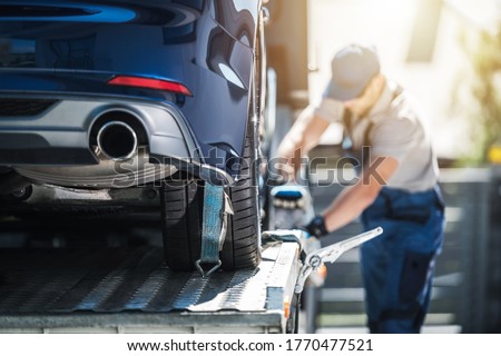 Towing Truck Delivery. Shipping Modern Vehicle to Car Dealership From Auction Lot. Transportation and Cargo Theme. Royalty-Free Stock Photo #1770477521