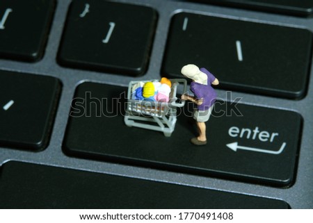 A woman doing safe solo shopping at supermarket wearing a face mask. Miniature people figurines toys conceptual photography.