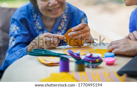 Elderly woman with caregiver in the needle crafts occupational therapy  for Alzheimer’s or dementia Royalty-Free Stock Photo #1770495194