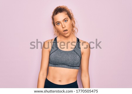 Young beautiful blonde sportswoman with blue eyes doing exercise wearing sportswear In shock face, looking skeptical and sarcastic, surprised with open mouth