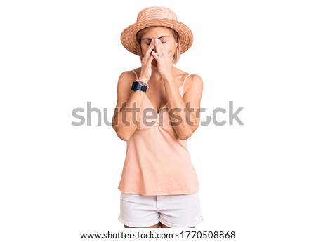 Young blonde woman wearing summer hat rubbing eyes for fatigue and headache, sleepy and tired expression. vision problem 