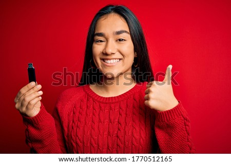 Beautiful activist asian woman asking for women rights holding banner with power message happy with big smile doing ok sign, thumb up with fingers, excellent sign