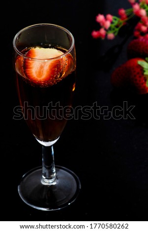A glass of rose wine with strawberries