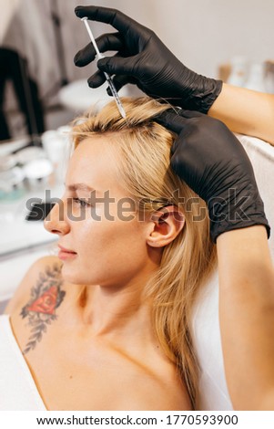 Young blonde woman with hair loss problem receiving injection, close up