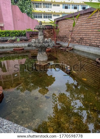 A small fountain in the garden pond