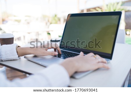 Selective focus on female hands typing program code during freelance job on modern laptop computer, cropped image of graphic designer creating web project during remote working on netbook technology