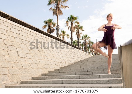 young ballet dancer posing on a stone staircase, dance concept and healthy lifestyle, copy space for text