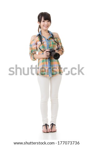 Young Asian woman with camera, full length portrait isolated on white background.