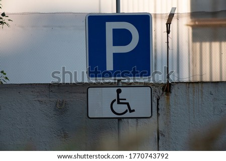 Disabled parking road sign. Big blue sign on a concrete fence.