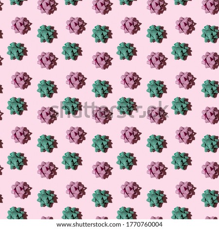 Seamless regular creative pattern with shiny bow from bright ribbon with dark shadow on pink paper. Printing on fabric, wrapping paper.