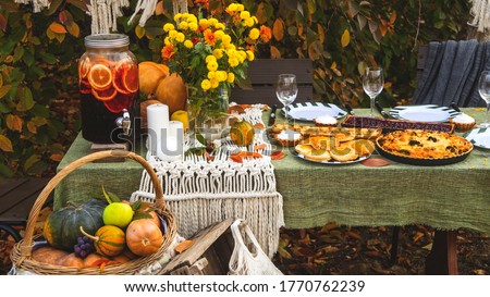 A festive autumn brunch among the yellow trees, with pumpkins, a yellow bouquet and pastries. Thanksgiving or family dinner in the backyard. Royalty-Free Stock Photo #1770762239