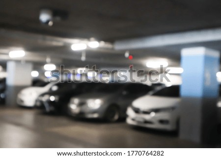 Blurred cars in car parking lot in shopping mall.