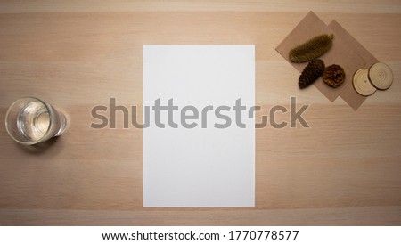 Mock up sheet of paper on wooden table with autumn decorations.
