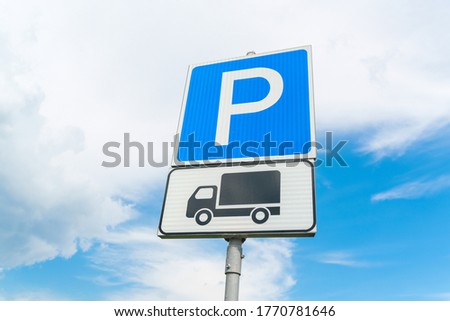 Lorry parking sign against the blue sky. Blue parking sign. Black truck on white plate. High quality photo