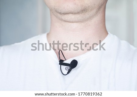 Lavalier microphone is attached to a T-shirt on a person before 