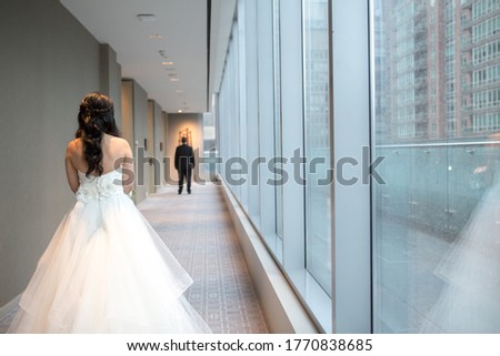 Bride walking towards groom through hallway