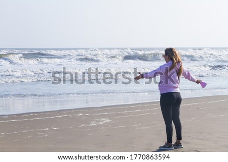 Woman on the shore looking at the sea