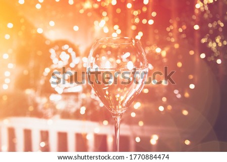 Cheers. Glass of champagne for New Year 2021 celebration. Beautiful christmas lights on the background