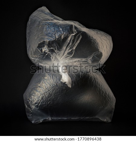 Clear disposable plastic bags on dark background.