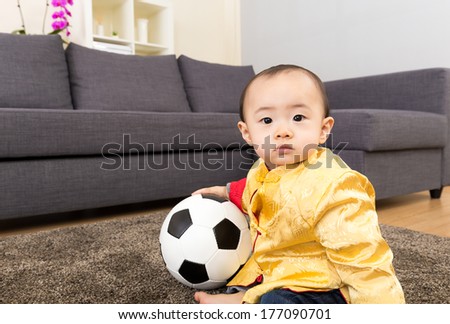Asia baby play soccer ball at home