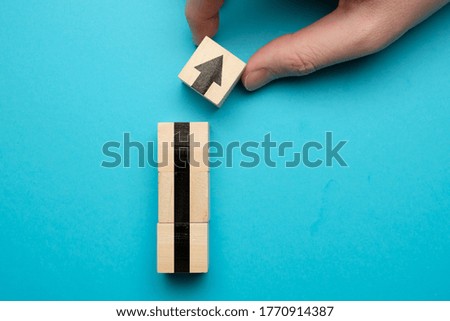 The concept of growth and business success. Wooden cubes with an arrow on a blue background