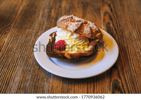 Vintage photography style of cream pastry puff dessert on wooden table top, selected focus.