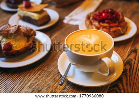Vintage photography style of Coffee and desserts pastry, puffs, tarts, cakes on wooden table top, selected focus.