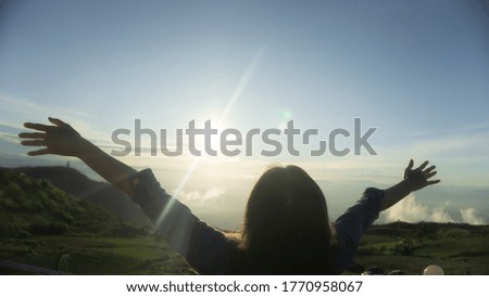 Strong women are happy with hope on top of mountain edge on sunrise blur background
