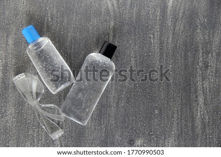 latex gloves, glasses, face masks and antibacterial gel on gray background for virus protection