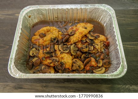 A baking dish with Chicken in a rich Marsala wine sauce and mushrooms.
